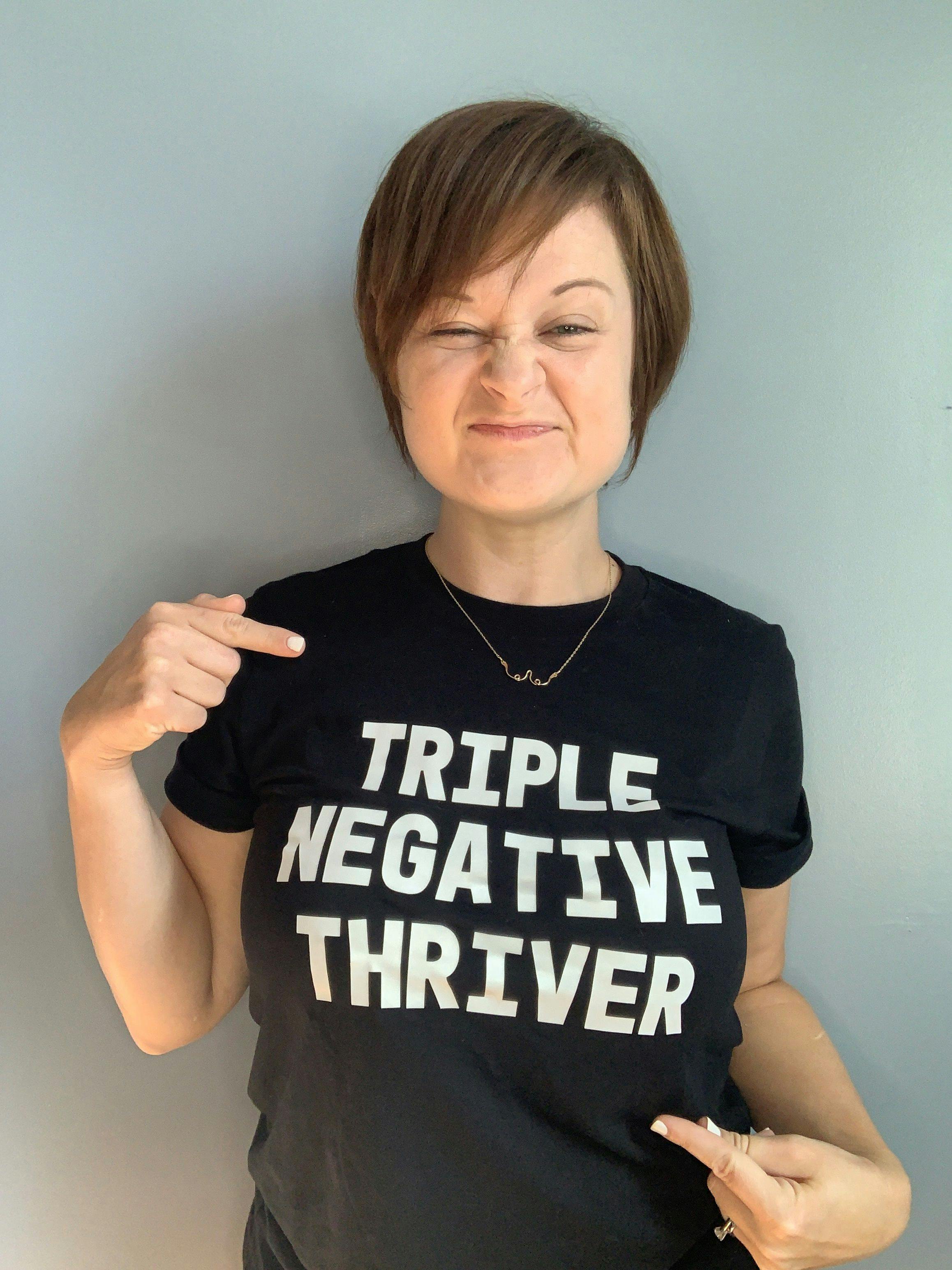 Kelly Thomas wearing a black shirt that says "TRIPLE NEGATIVE THRIVER"