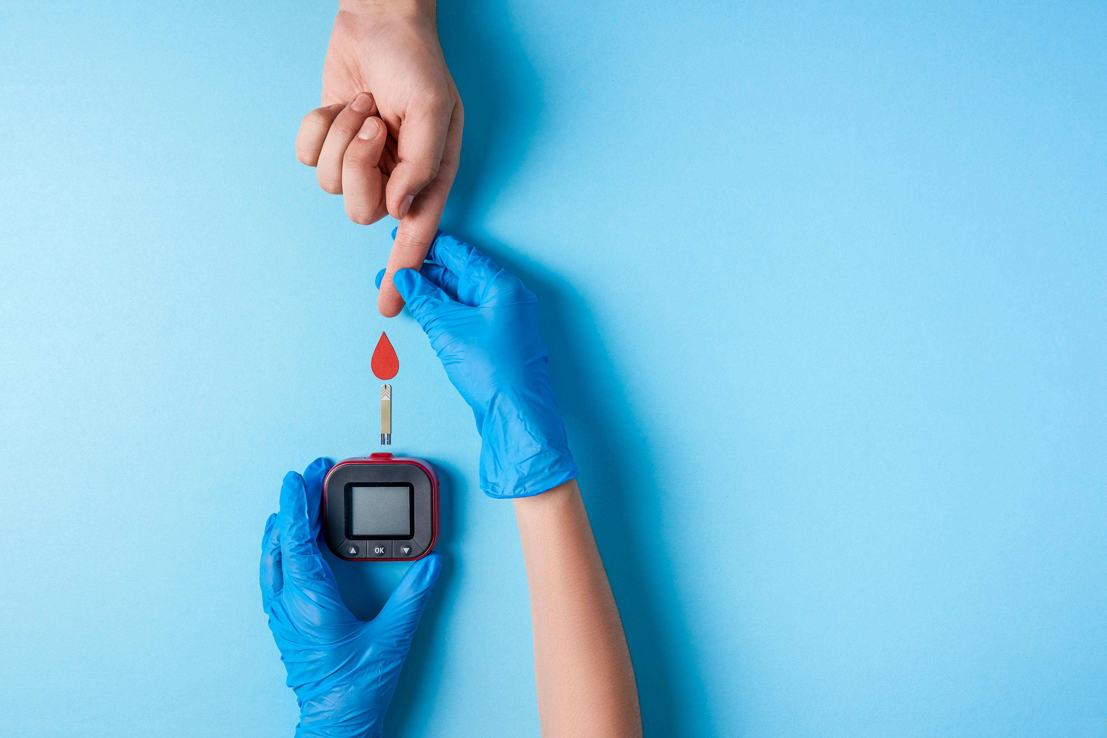 Nurse making a blood test. Man's hand with red blood drop with Blood glucose test strip and Glucose meter | Image credit: © KaterynaNovikova - © stock.adobe.com